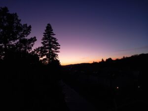Crépuscule, où l'on voit le ciel avec des teintes douces allant de l'orange au loin, puis vers le rose, puis vers le violet et le bleu nuit.